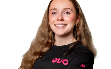 Kvinne som st&aring;r med kryssede armer i en Evo t-skjorte.