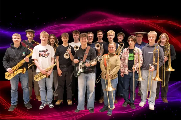 En gruppe folk med instrumenter står sammen, et ungdomsstorband.